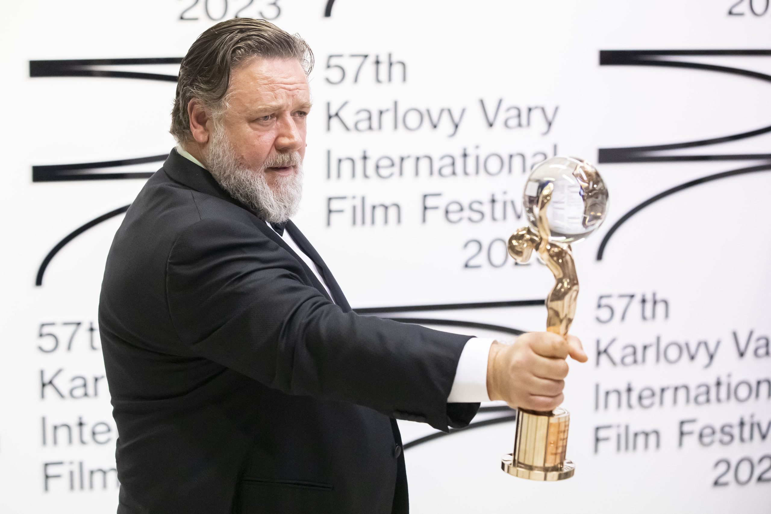 Actor Russell Crowe holding up his Crystal Globe Award on a red carpet during the 57th Karlovy Vary International Film Festival in Czech Republic.