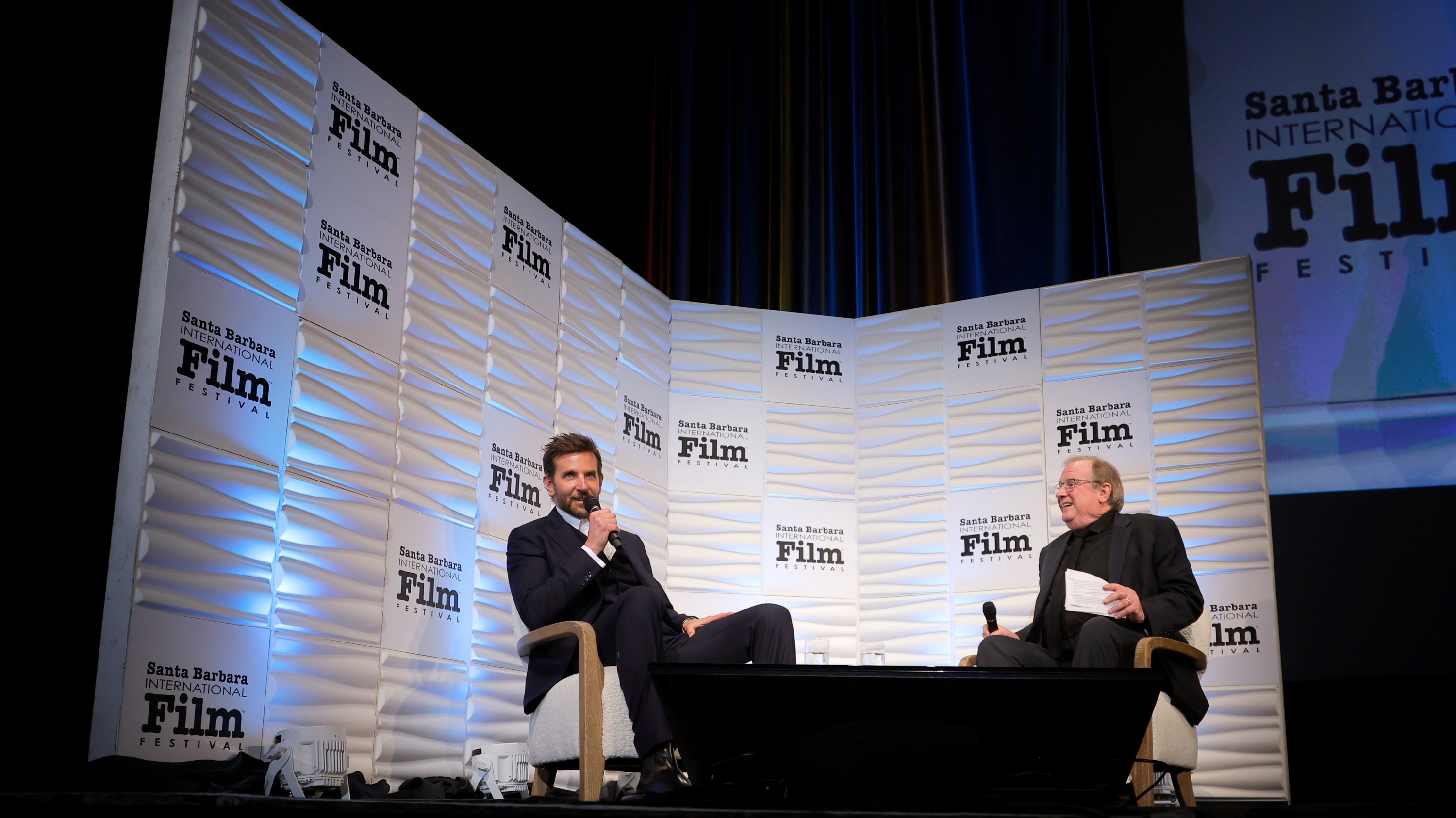 SANTA BARBARA, CALIFORNIA - FEBRUARY 08: Bradley Cooper and Pete Hammond speak onstage at the Outstanding Performer of the Year Award ceremony during the 39th Annual Santa Barbara International Film Festival at The Arlington Theatre on February 08, 2024 in Santa Barbara, California. (Photo by Tibrina Hobson/Getty Images for SBIFF)